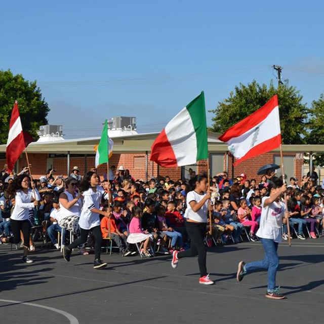 Students at Carrillo carry flags from other nations during the Day of Peace assembly.